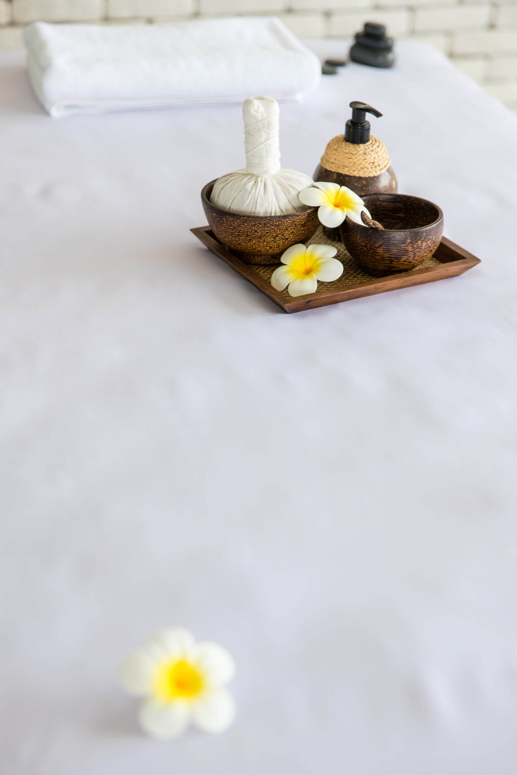 Closeup Shot Thai Massaging Stuffs Herbal Towel Compress Ball Coconut Oil Perfume Cosmetics Plumeria Flower Wooden Tray Placing Massage Bed Spa Therapy Preparing Customer2 Scaled